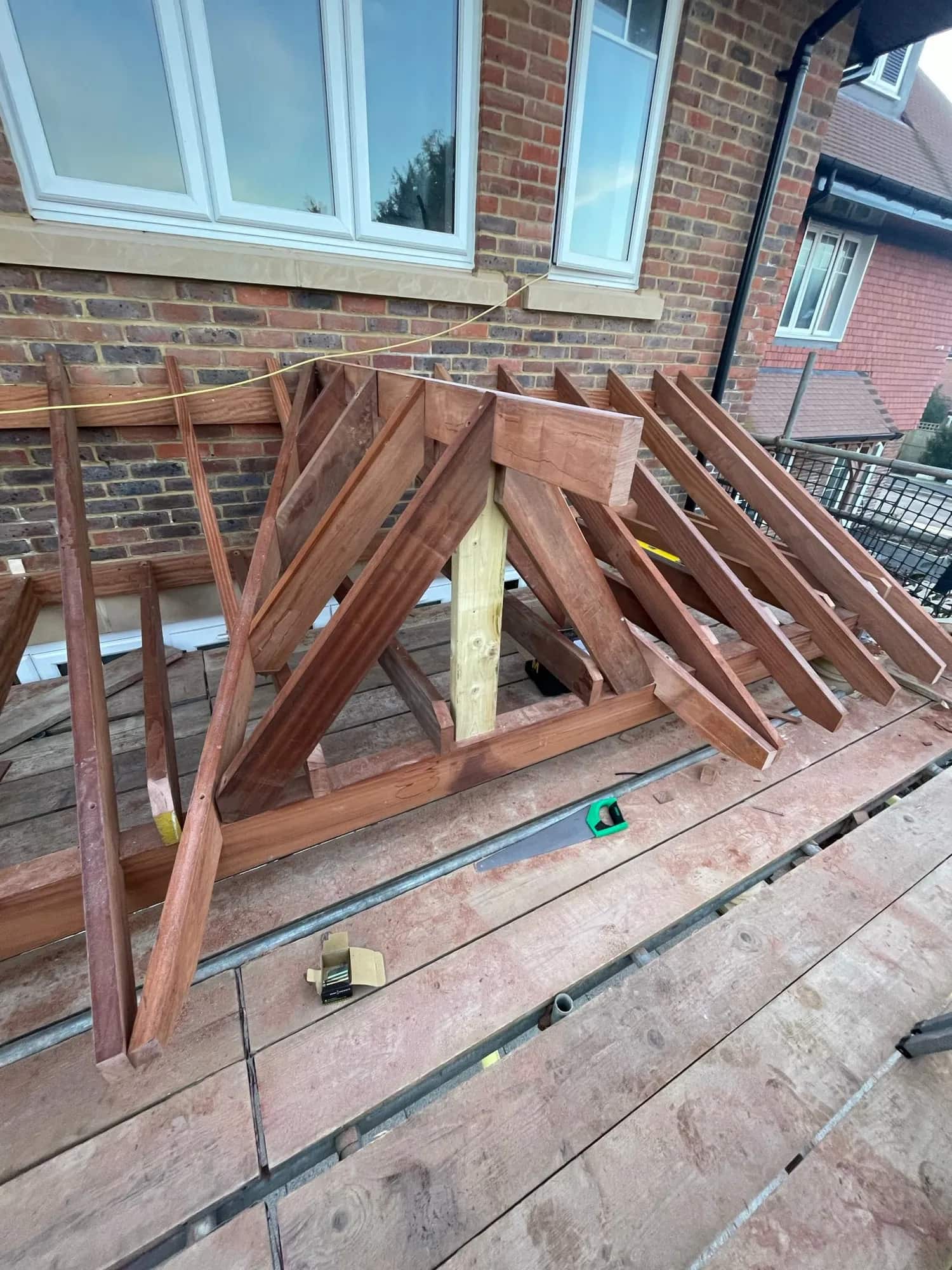 Hand-cut and pitched hardwood roof structure being assembled on a scaffold